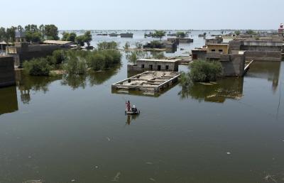 People use a makeshift raft to navigate floodwaters from monsoon rains, in the Dadu district of Sindh Province in Pakistan, on September 9, 2022. (AP Photo/Fareed Khan)