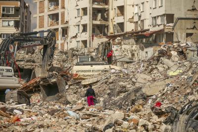 A man walks among debris as excavators demolish the remains of a destroyed building following the earthquake in Samandag, southern Turkey, on February 22, 2023. (AP Photo/Emrah Gurel) 