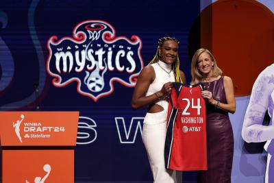 Aaliyah Edwards receives a Washington Mystics’ jersey after being chosen by the team during the WNBA basketball draft. (AP Photo/Adam Hunger)