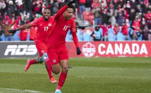 Team Canada’s Tajon Buchanan (11) celebrates his goal with teammate Cyle Larin after scoring against Jamaica during first half men's World Cup qualifier soccer action in Toronto on March 27, 2022. (THE CANADIAN PRESS/Nathan Denette)