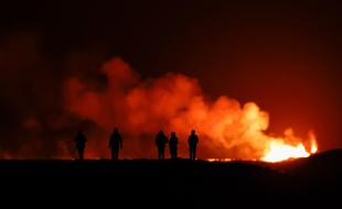People watch as a volcano erupts in southwest Iceland. (Photo via Getty Images’ Facebook page.)
